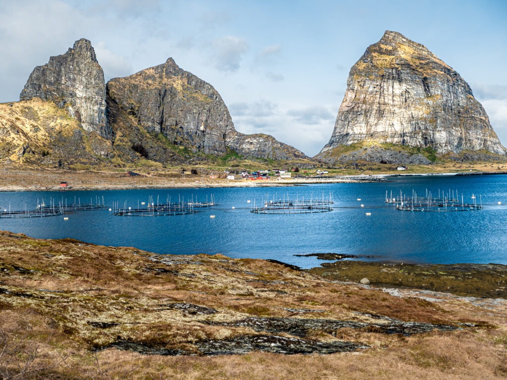 Blick über einen Meeresarm auf eine spektakuäre Felsformation auf Traena, Norwegen